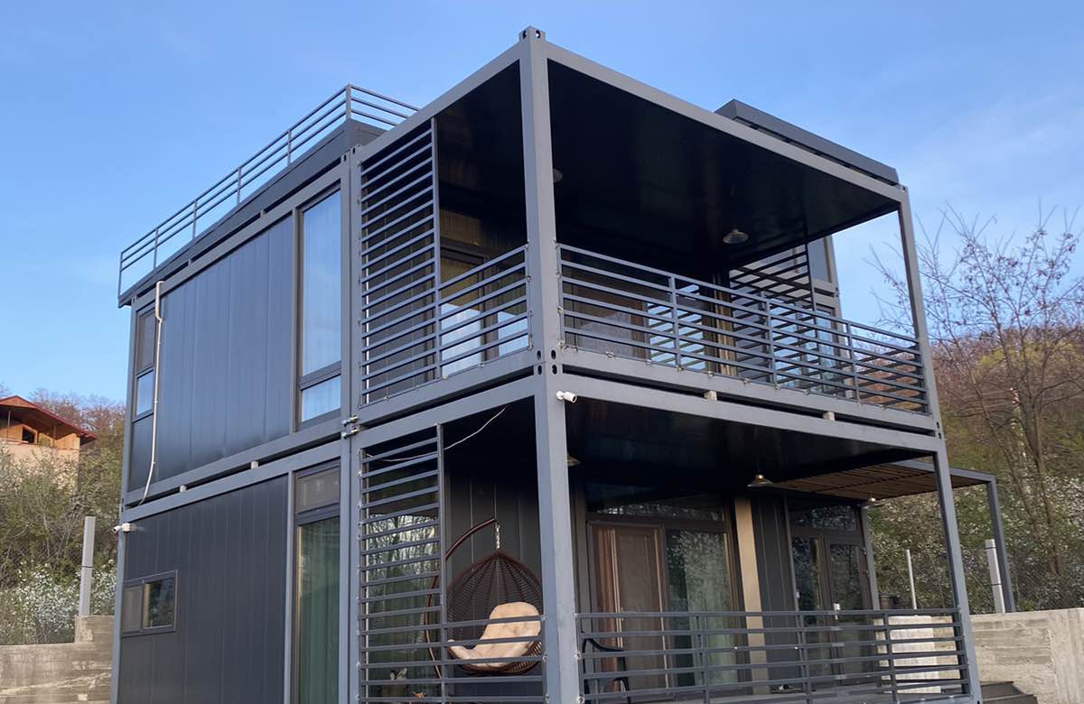 Imagine a unei case modulare din containere, modernă și funcțională, evidențiind construcții eficiente în spații compacte.