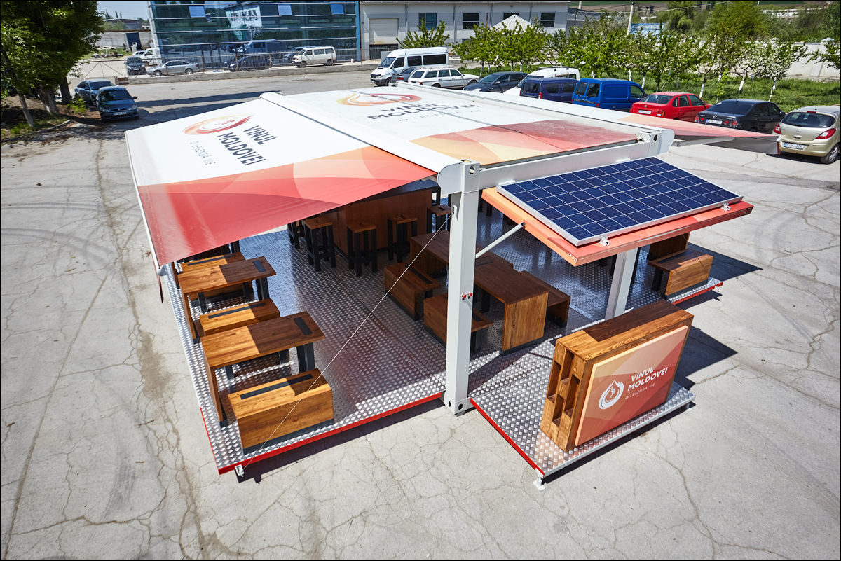 Imagine ce ilustrează construcții modulare realizate din containere, prezentând un complex de case moderne și funcționale, integrate armonios în peisajul natural.