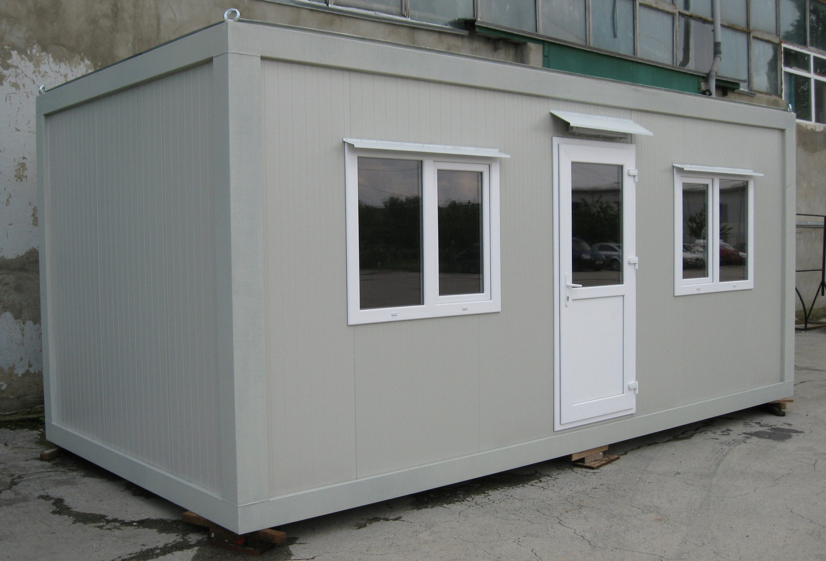Imagine care ilustrează o construcție modulară din containere, prezentând un design modern și funcțional, evidențiind eficiența și versatilitatea caselor din containere.